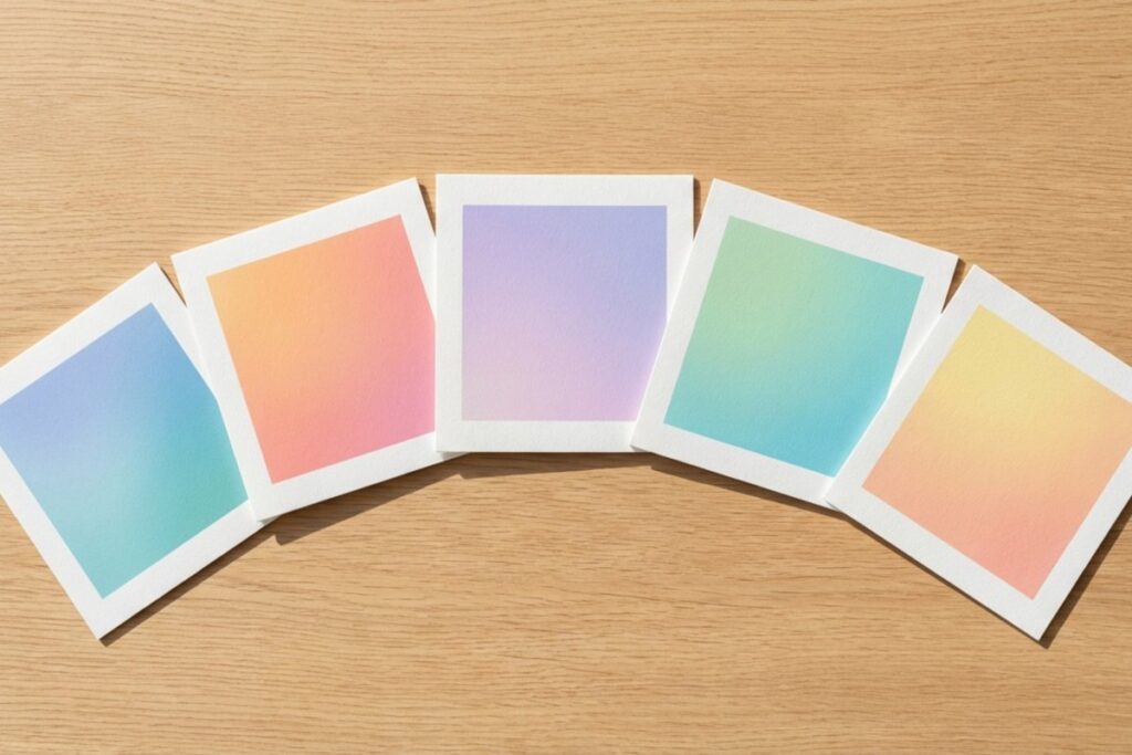 木目のテーブルに並んだ5枚のグラデーションカラーカードと紙フレーム。色とカードを使って1on1対話で思考を整理する。